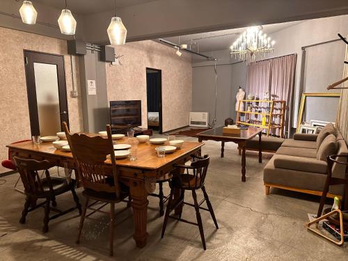 a living room with a wooden table and chairs at Economy Hotel Upashi in Asahikawa