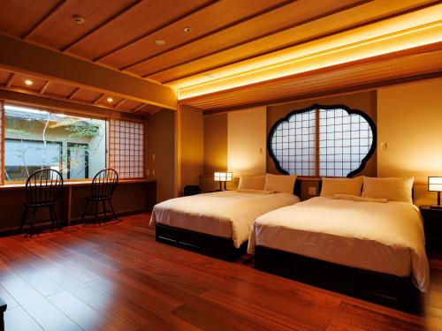 a hotel room with two beds and a window at Shoraiso in Yamanouchi