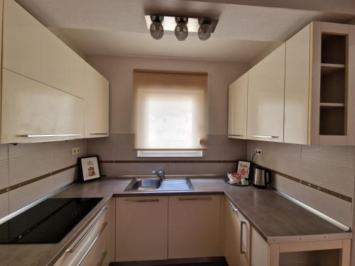 a kitchen with white cabinets and a sink at Apartman Lončar Posušje in Posušje
