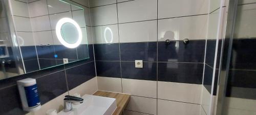 a bathroom with a sink and a mirror at Brit Hotel Confort Manosque Cadarache in Manosque