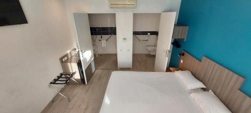a small room with a bed and a bathroom at Brit Hotel Confort Manosque Cadarache in Manosque