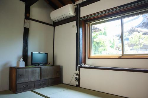 a living room with a tv and a window at みずまの宿 - Mizuma no yado in Kubo