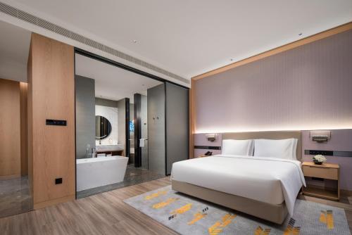 a bedroom with a large bed and a bath tub at Holiday Inn Guiyang Airport by IHG in Guiyang