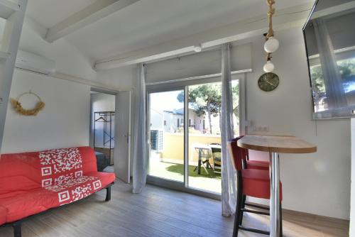 un salon avec un canapé rouge et une table dans l'établissement Appartement résidence EUREKA T2-piscine-parking, au Cap d'Agde