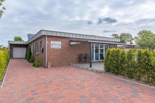 a brick building with a brick driveway at Ferienhaus Nordsee-Chalet in Bensersiel