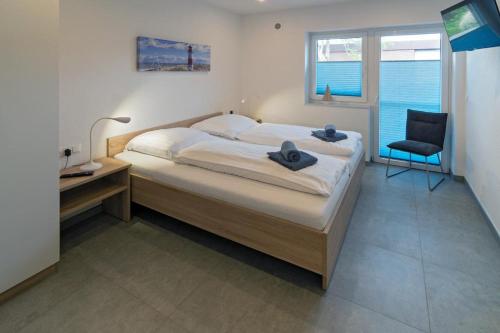 a bedroom with a bed and a desk and a chair at Ferienhaus Nordsee-Chalet in Bensersiel