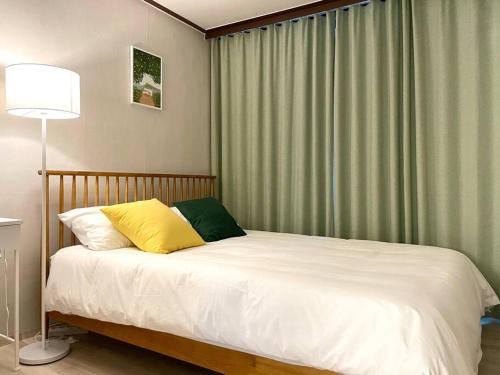 a bed with two pillows and a lamp in a bedroom at Indeogwon Hue Stay in Anyang
