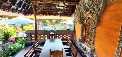 a dining room with a long table in a restaurant at Stana Puri Gopa Hotel in Sanur