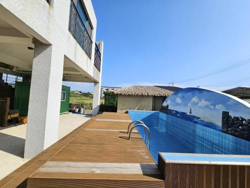 a swimming pool with a mirror on the side of a building at Jemibareut Pension in Jeju