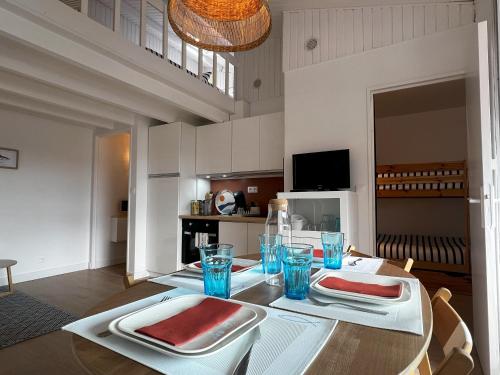 ein Esszimmer mit einem Tisch mit zwei Gerichten darauf in der Unterkunft Narbonne-Plage Méditérranée in Narbonne-Plage