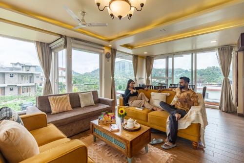 a man and woman sitting on a couch in a living room at Alaya Stays Celestial Rhapsody 3BHK Villa in Nainital in Nainital