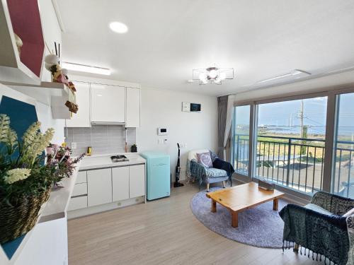 a kitchen and living room with a view of the ocean at Jemibareut Pension in Jeju
