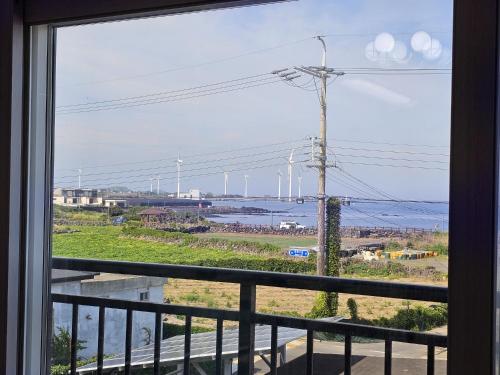 a window of a balcony with a view of the ocean at Jemibareut Pension in Jeju
