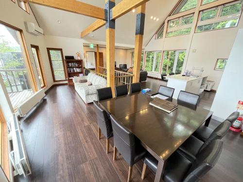 a dining room and living room with a table and chairs at Furano Lodge 10 by H2 Life in Furano