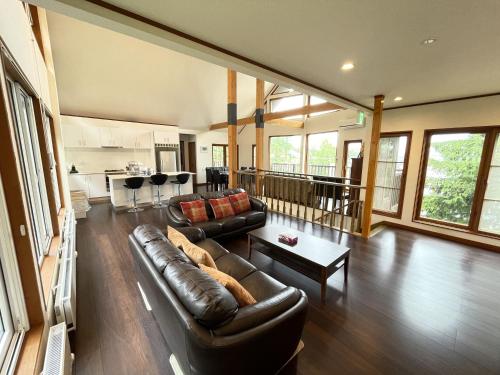 a living room with a couch and a table at Furano Lodge 10 by H2 Life in Furano