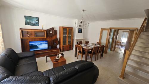 a living room with a couch and a dining room at SURFANDO NO BALEAL 8 pessoas in Ferrel