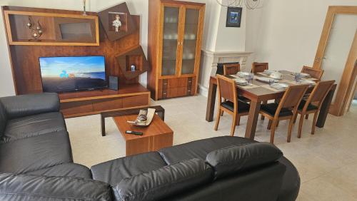 a living room with a couch and a table with a television at SURFANDO NO BALEAL 8 pessoas in Ferrel
