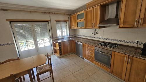 a kitchen with wooden cabinets and a table and a tableablish at SURFANDO NO BALEAL 8 pessoas in Ferrel