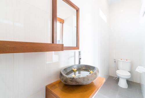 a bathroom with a large stone sink in the corner at Raka Rai Homestay in Canggu