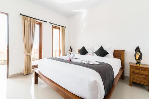 a bedroom with a large bed with two towels on it at Raka Rai Homestay in Canggu