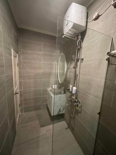 a bathroom with a shower with a fan and a mirror at Rent Studio full furnished in Jakarta