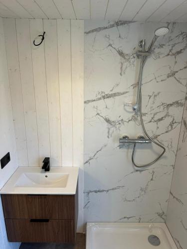 a white bathroom with a sink and a shower at Melluži tiny house 60m2 in Jūrmala