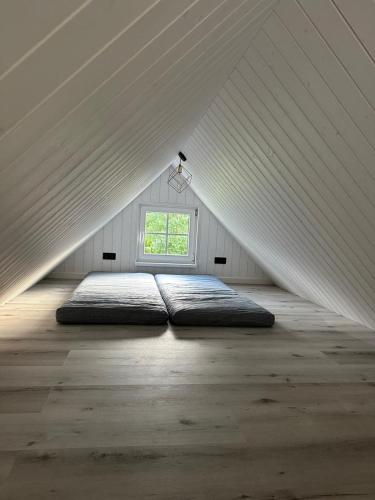 a bed in a attic room with a window at Melluži tiny house 60m2 in Jūrmala