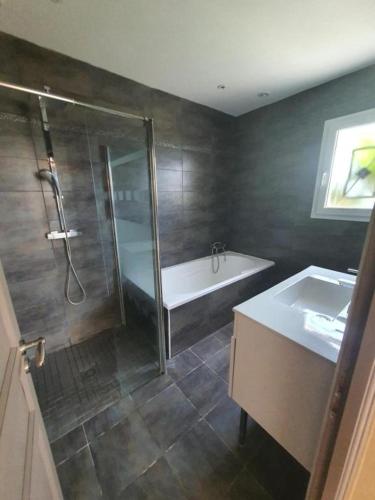 une salle de bain avec une douche, une baignoire et un lavabo dans l'établissement Bienvenue a l hacienda, à Magalas