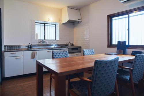 a kitchen with a wooden table and chairs at Suikomareso in Hita