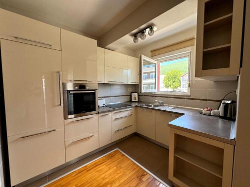 a large kitchen with white cabinets and a window at Apartman Lončar Posušje in Posušje
