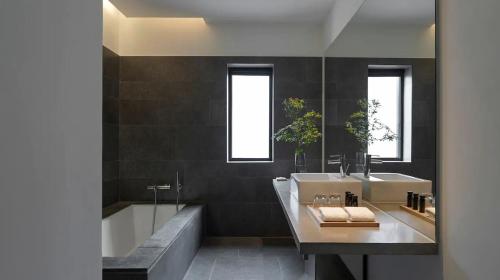 a bathroom with a tub and a sink and a bath tub at Commune by the Great Wall, in the Unbound Collection by Hyatt in Yanqing