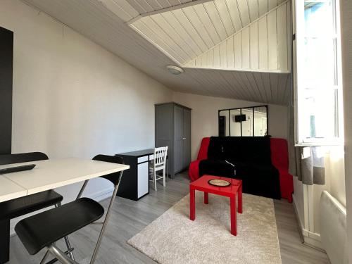 - un salon avec un canapé et un tabouret rouge dans l'établissement Charmant studio Carmes 5 - CDDT, à La Rochelle