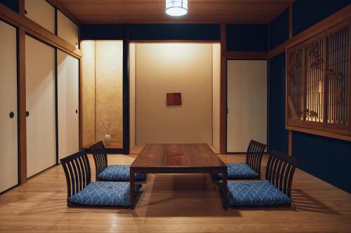 a dining room with a wooden table and two chairs at Suikomareso in Hita