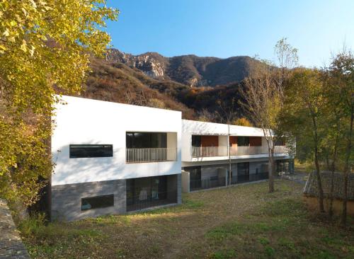 a white building with a mountain in the background at Commune by the Great Wall, in the Unbound Collection by Hyatt in Yanqing