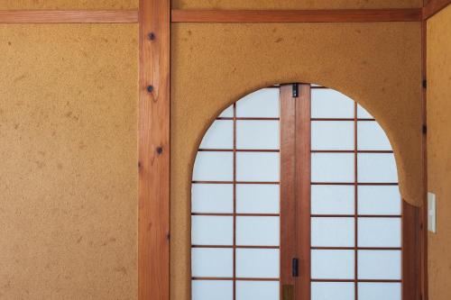 an arched window in a room with wood at Suikomareso in Hita