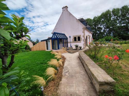 a small white house with a blue roof at Au Pti' Bonheur in Saint-Coulomb