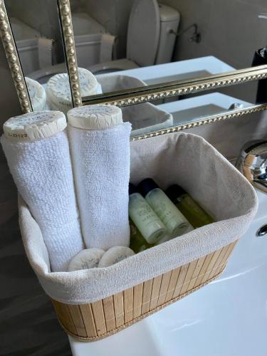 a basket sitting on a sink with towels at Sofia Residence Apartments Cetate in Târgu Neamț