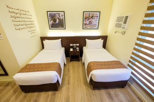 a room with two beds in a room at Cebu Quincentennial Hotel in Cebu City