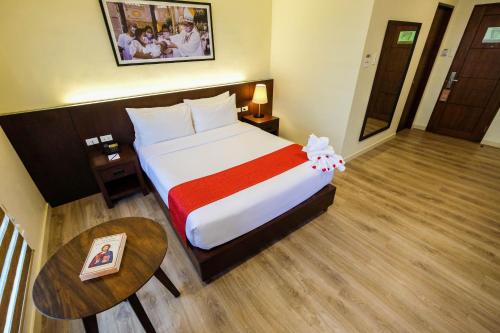a hotel room with a large bed and a table at Cebu Quincentennial Hotel in Cebu City