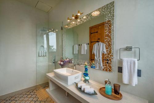 MulshiにあるSaffronStays Satori Perch Royale - 3 Bedroom Apartment in Mulshiの洗面台と鏡のあるバスルーム