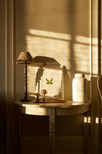 a table with a lamp and a clock on it at Rimforsa Strand in Rimforsa