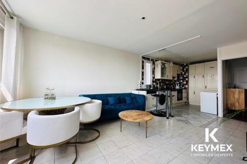 un salon avec un canapé bleu et une table dans l'établissement Chanane, à Épinay-sur-Seine