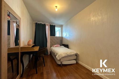 une petite chambre avec un lit et un bureau dans l'établissement Chanane, à Épinay-sur-Seine