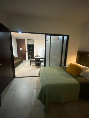 a bedroom with a bed and a living room at Loft, Departamento cerca del Malecon, MAZATLAN in Mazatlán