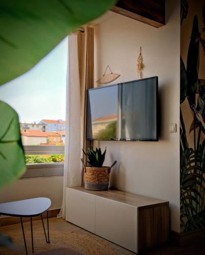 un salon avec une télévision à écran plat sur un mur dans l'établissement - Voile -, à Canet