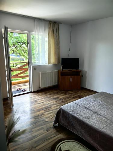 a bedroom with a bed and a sliding glass door at Casa Eliza in Ocna Şugatag