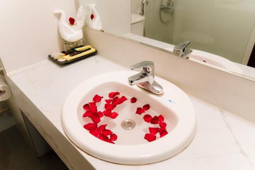 a white bathroom sink with red hearts in it at Bạch Đằng Hạ Long Hotel in Ha Long
