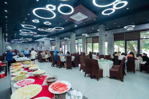 a dining room with tables with plates of food at Bạch Đằng Hạ Long Hotel in Ha Long