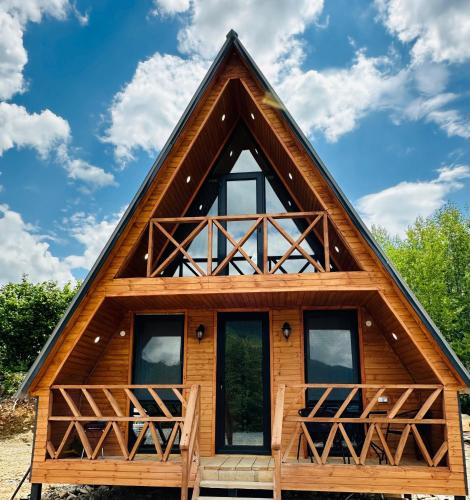 a frame cabin with a thatched roof at Villa Wood in Mestia N 2 in Mestia