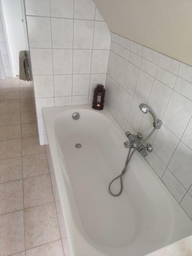 a bath tub in a bathroom with a clock on it at Enjoy in Wenduine